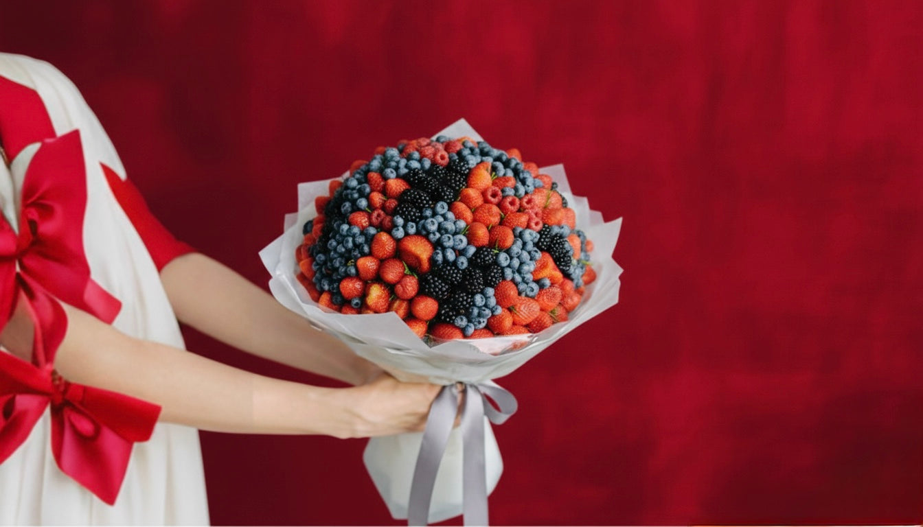 Bouquet of berries held by a person against a red background