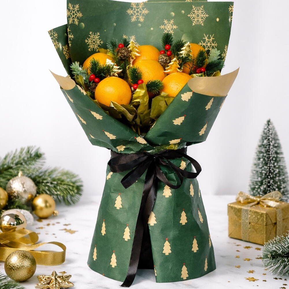 Bouquet of fruits wrapped in green paper with gold tree patterns, surrounded by Christmas decorations.