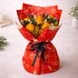 Bouquet of oranges wrapped in red festive paper with a black ribbon on a light background