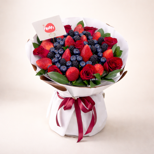Red roses and mixed berries bouquet with fresh strawberries, blueberries and blackberries for romantic gifting and same-day delivery in Dubai by Fruitify.