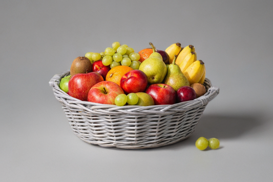 Fruit basket with apples, grapes, and pears on a gray background