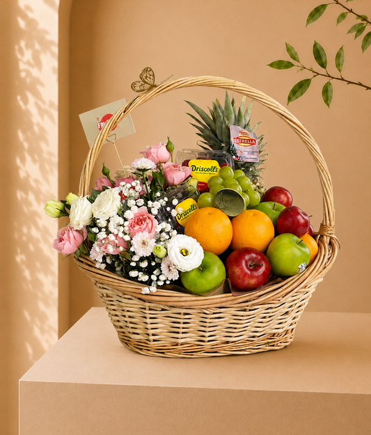 Luxury fruit and flower basket with fresh roses, gypsophila, berries, grapes, apples, oranges, and premium seasonal fruits in an elegant wicker basket for gifting in Dubai.