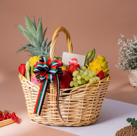 Luxury seasonal exotic fruit basket featuring pineapple, dragon fruit, grapes, strawberries, apples, bananas, and premium seasonal fruits in a handcrafted wicker basket with UAE ribbon, perfect for gifting in Dubai and UAE.