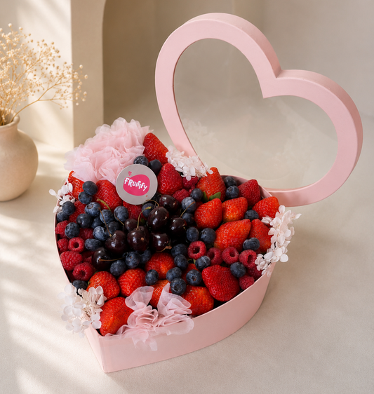Luxury heart-shaped berry gift box with fresh strawberries, blueberries, raspberries, cherries, and floral accents in pink packaging for gifting in Dubai.
