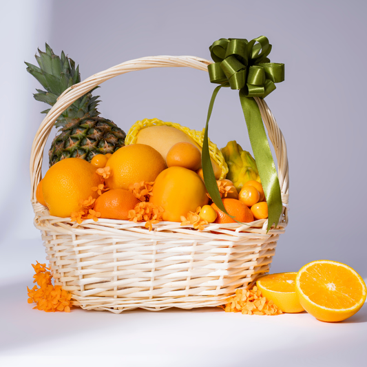 Premium citrus fruit basket featuring oranges, pineapple, melon, golden berries, star fruit, and seasonal yellow fruits in an elegant wicker basket, perfect for healthy gifting in Dubai