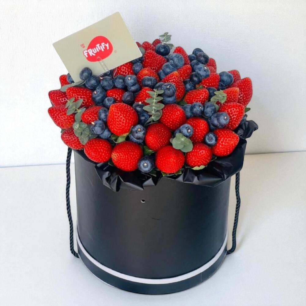 Black box filled with strawberries and blueberries, branded 'Fruity'.