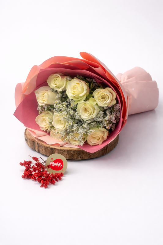 Bouquet of white roses wrapped in pink paper on a white background