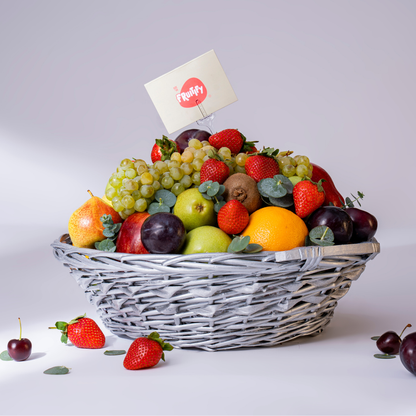 Fruit basket with a variety of fruits including apples, oranges, and strawberries on a white background.