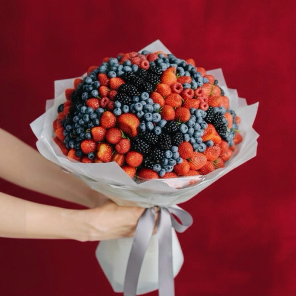 Luxury mixed berry bouquet with fresh strawberries, blueberries, raspberries, and blackberries in elegant wrapping by FruitifyAE, same-day gift delivery Dubai.