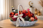 Fruit basket with a bottle of wine on a table in a room with decor elements.