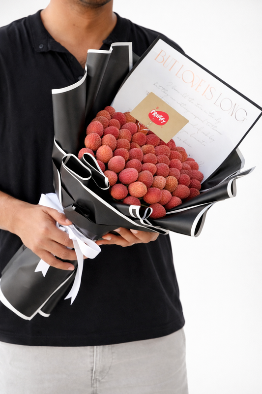 Person holding a bouquet of raspberries with a magazine inside, against a white background
