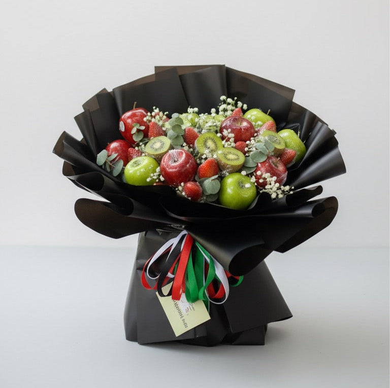 Bouquet of fruits wrapped in black paper with a decorative ribbon on a white background
