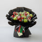 Bouquet of fruits wrapped in black paper with a decorative ribbon on a white background