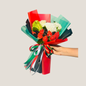 Bouquet of flowers with red and green ribbons held by a hand on a light gray background